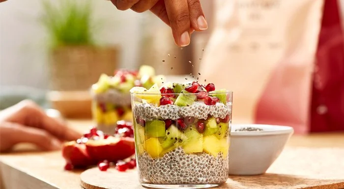 Layered chia seed pudding topped with kiwi, mango and pomegranate seeds