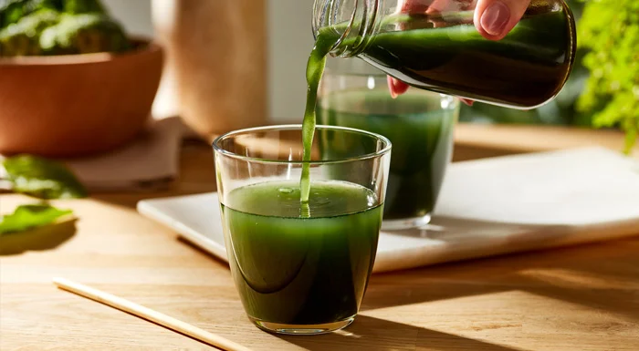 Green juice being poured into a glass