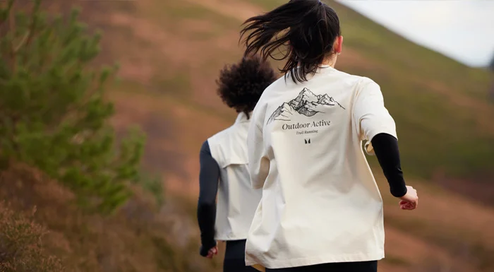 Two people running up a hillside