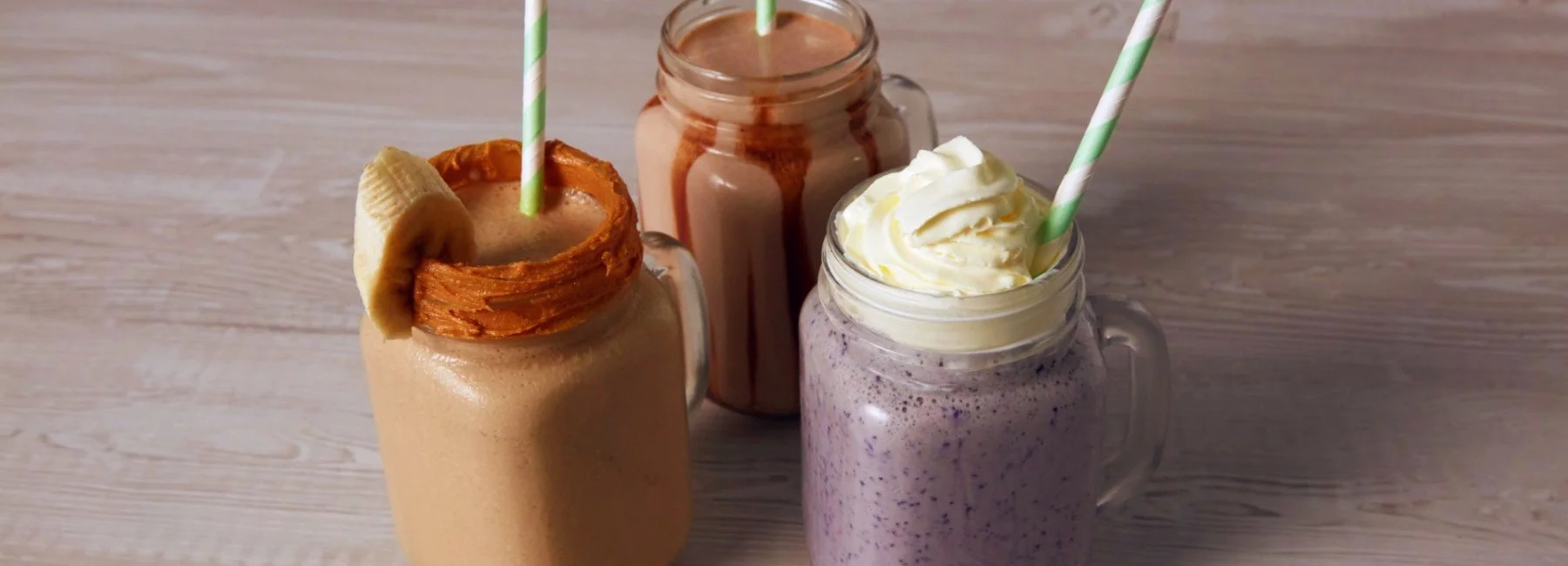 Three budget bulking shakes in jam jar glasses with straws