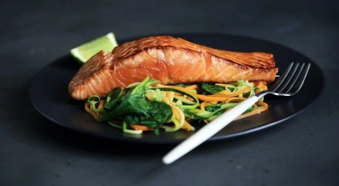Salmon fillet on a bed of spinach and vegetable noodles