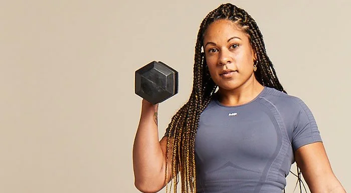 Woman holding a dumbbell in a grey Myprotein top