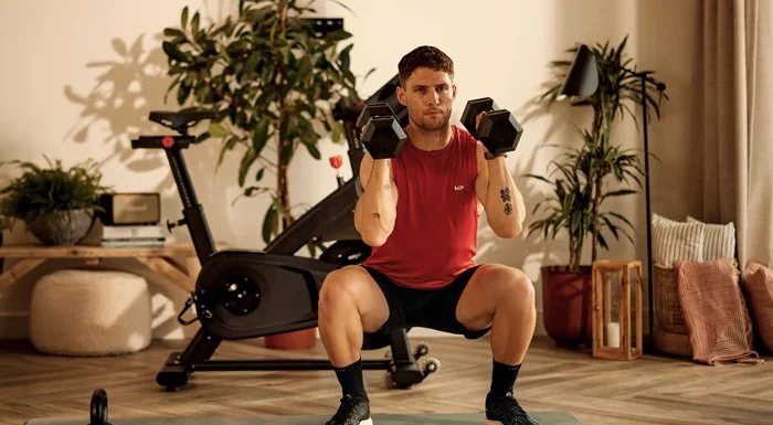 Man doing a dumbbell squat at home