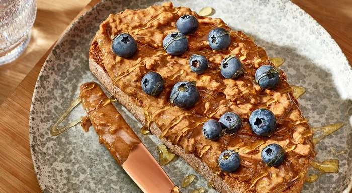 Toast spread with peanut butter and topped with blueberries