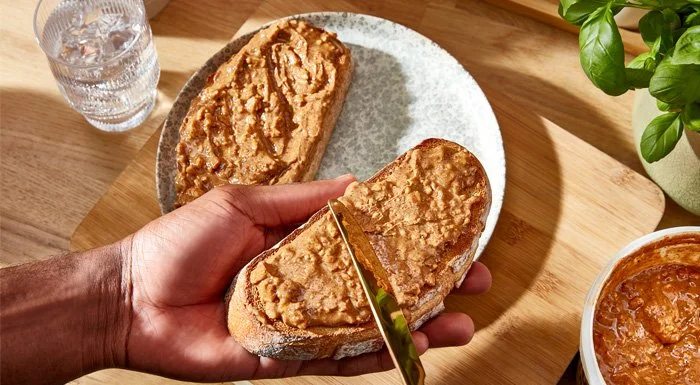 Hand holding toast spread with peanut butter