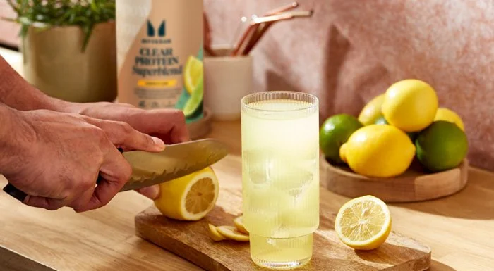Lemons being sliced next to a glass of Myvegan Clear Protein