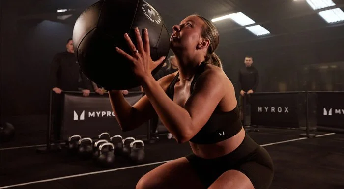 Woman doing a wall ball throw at a HYROX event