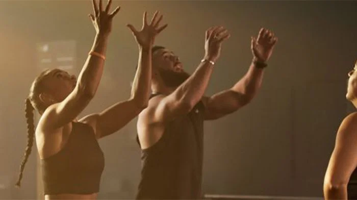 Group of people raising their arms during a fitness class
