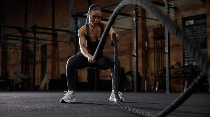 Woman training with battle ropes in a gym