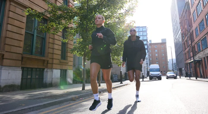 Man and woman running along a city street