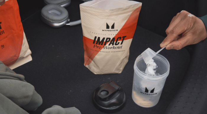 Scoop of Myprotein Impact Pre-Workout being added to a shaker
