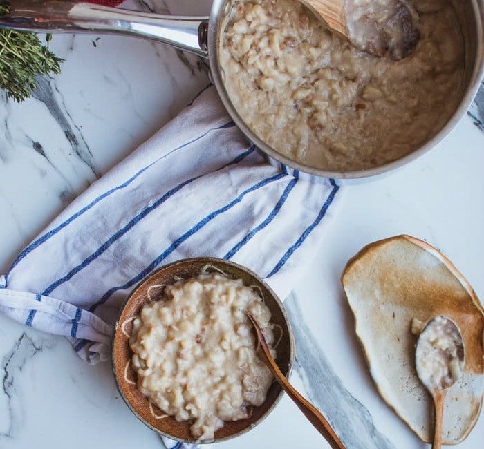 Apple pie protein porridge in a bowl and a saucepan