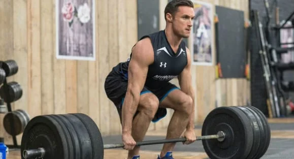 Man setting up to deadlift a heavy barbell in the gym