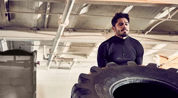 Man flipping a tractor tyre in the gym