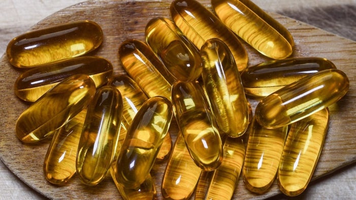 Fish oil softgel capsules on a wooden board