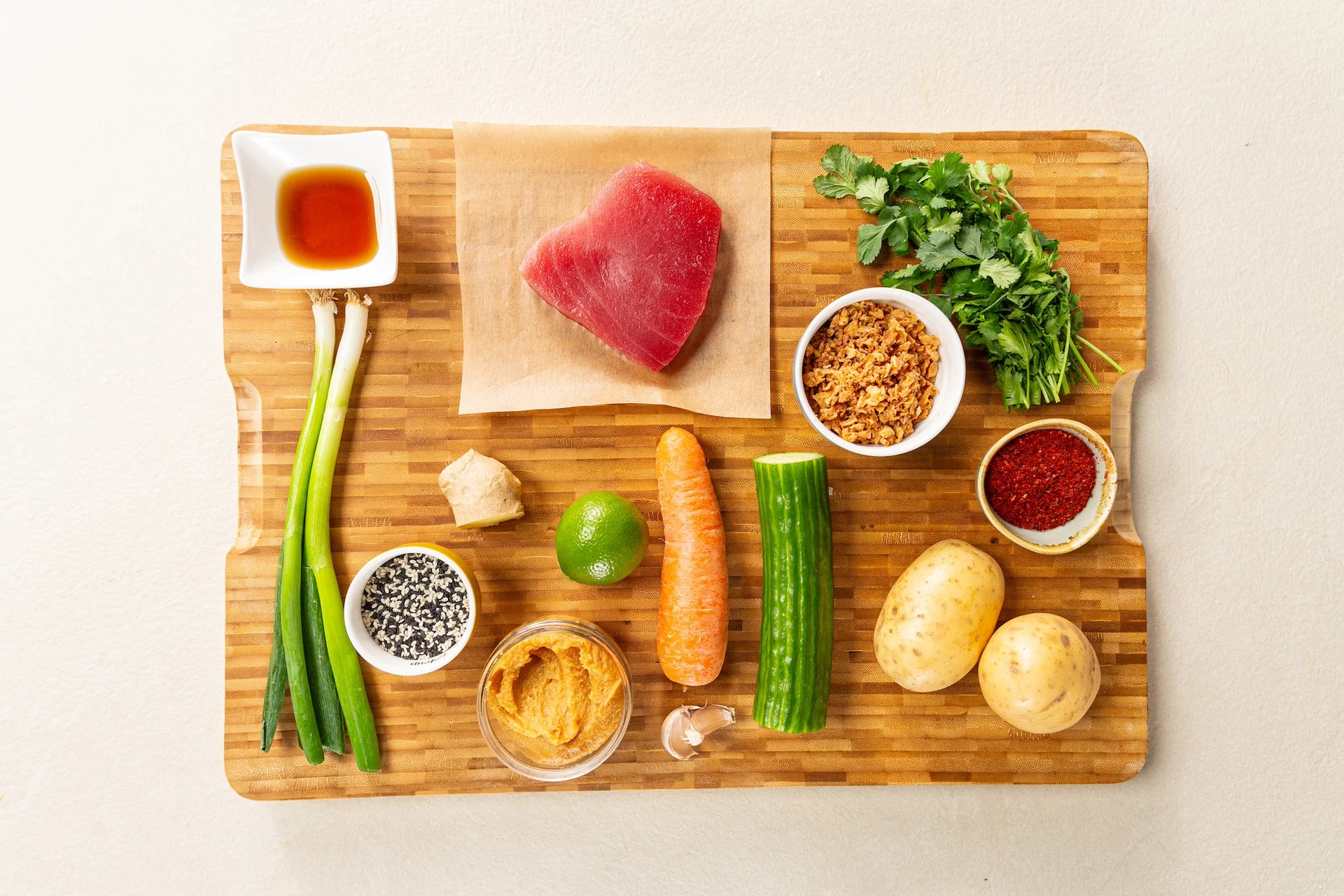 Tuna steak raw ingredients lay out on a chopping board ready for preparation.