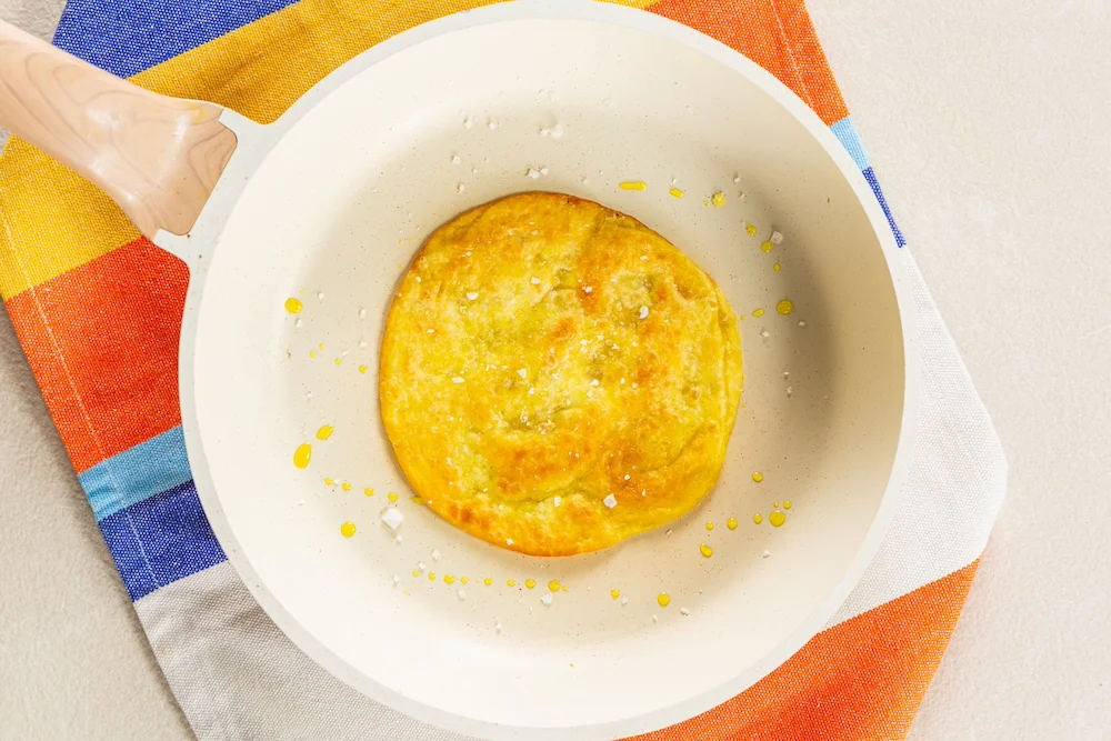 Tortilla is placed in the pan to heat up.