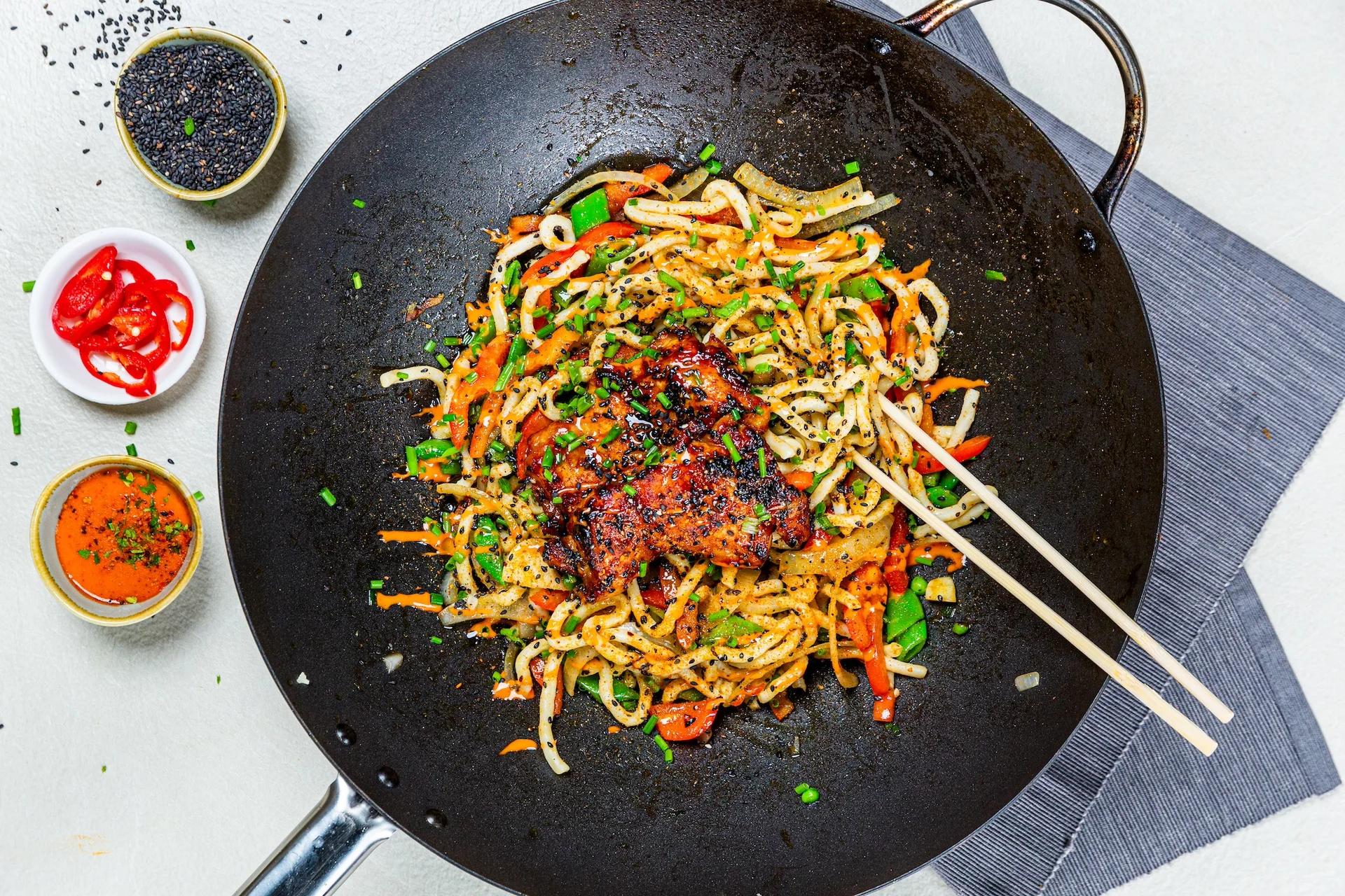 Teriyaki noodles in a wok with vegetables.